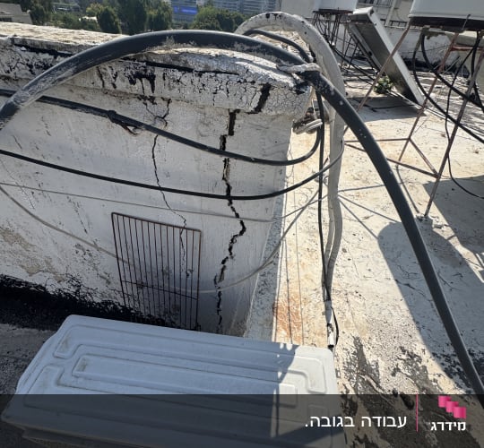 גג עם סדקים וצינורות, מבנים ברקע